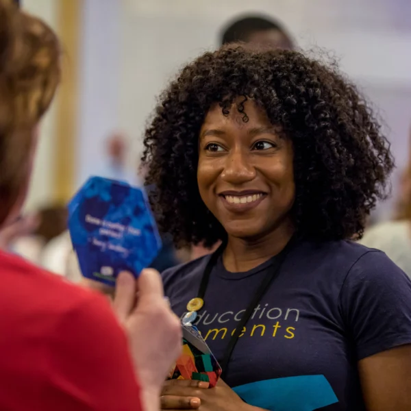 Woman smiling while interacting with another participant at a conference