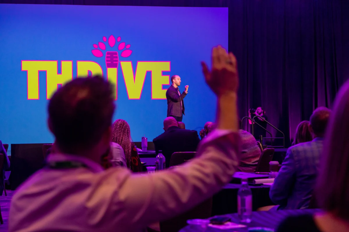 Attendees raise their hands during an interactive keynote