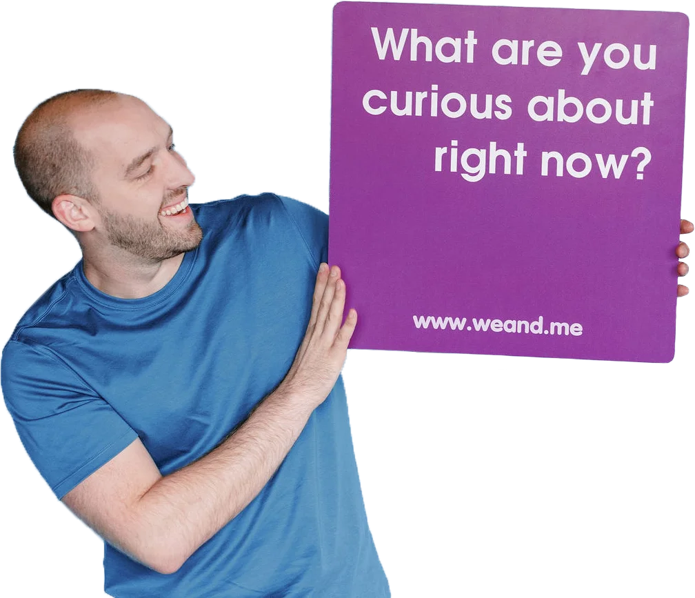 Chad Littlefield holds up a large card that reads What are you curious about right now?